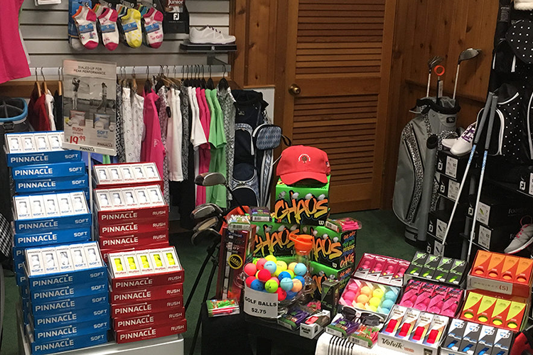 view of merchandise in pro shop including socks, a hat, tees,apparel, golf balls, and clubs